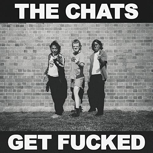Black and white album cover featuring three people standing against a brick wall.