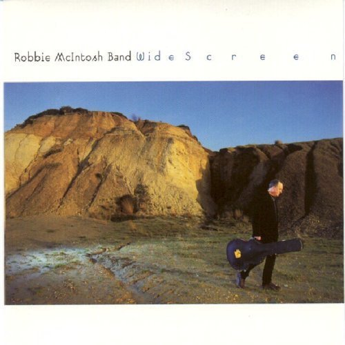 "CD cover with a man skateboarding in front of a rocky cliff."