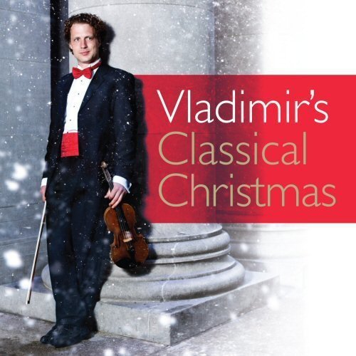 Man in tuxedo holds violin, standing on stone steps, with red banner beside him.