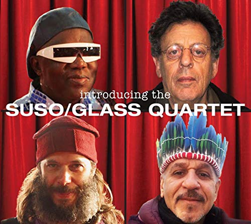 Four musicians with diverse headwear against a red curtain backdrop.