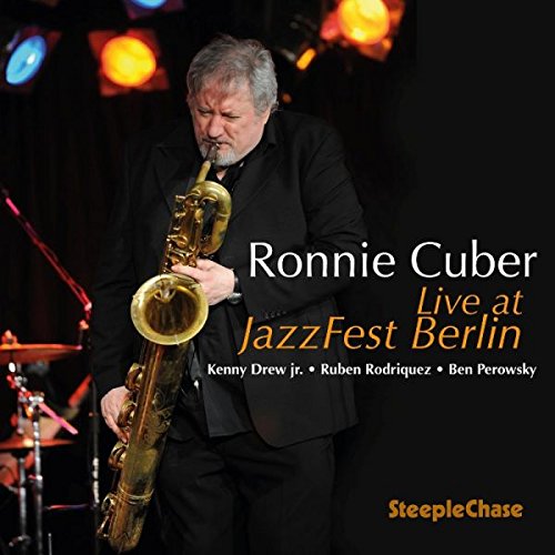 "Album cover featuring a man playing a saxophone on stage with stage lights."