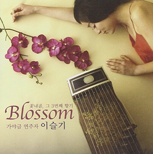 CD cover featuring a woman, purple orchids, and a gayageum musicalL musical instrument.