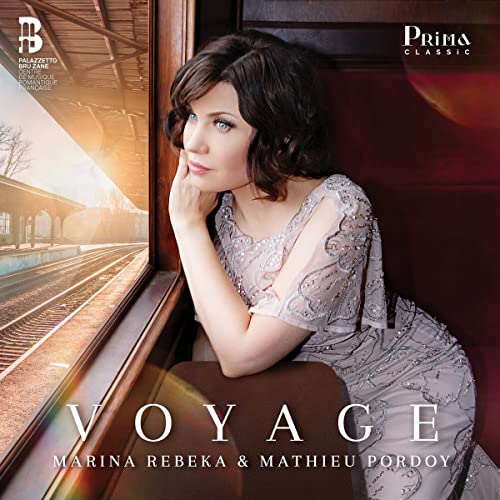 CD cover: opera singer Marina Rebeka poses by a train window.