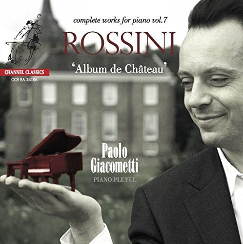 CD cover featuring a man holding a red grand piano, with a building in the background.