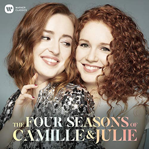 "Album cover featuring two smiling women with curly hair, against a gray background."