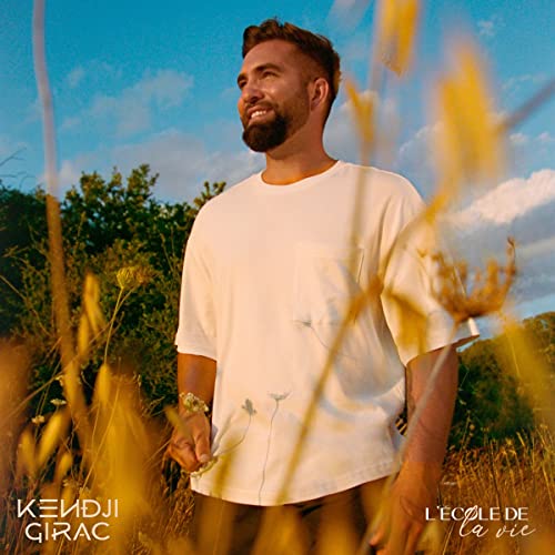 Kendji Girac album cover, man in field with tall grasses.