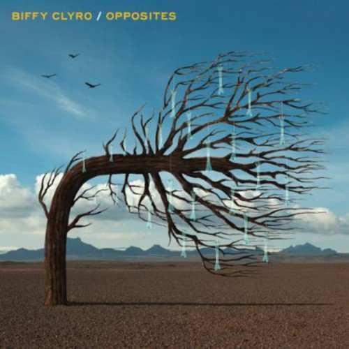 "Bare tree with icicles in a desert landscape, blue sky with birds."