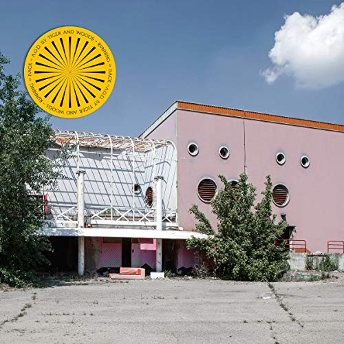 Album cover: pink building with a yellow sunburst graphic overlay.