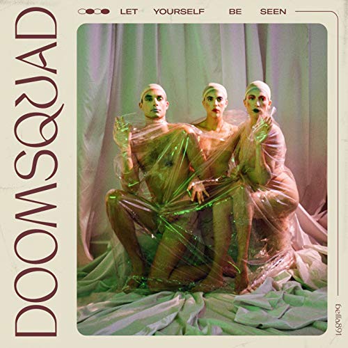 Album cover: three figures wrapped in plastic, with bold text.