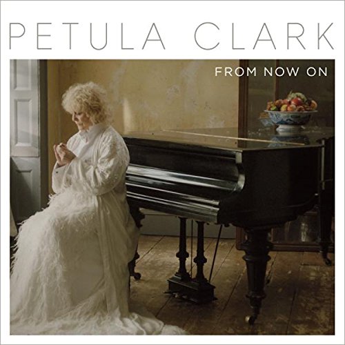 "CD cover featuring a woman in white sitting beside a piano."