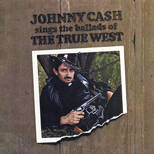 "Album cover with torn photo of man holding gun, on wooden background."