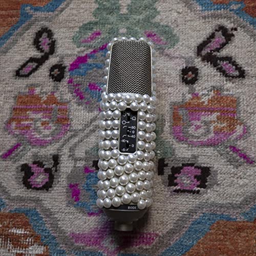 Vintage microphone decorated with pearls on a patterned rug.