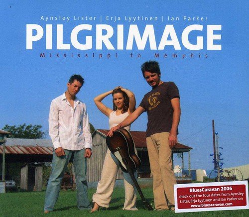 "CD cover featuring three musicians standing together on grass in front of a barn."