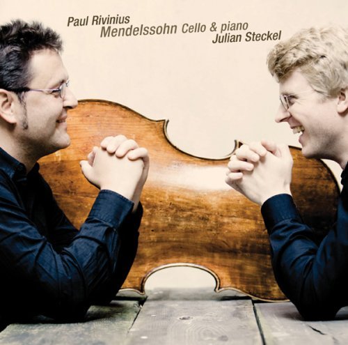 "CD cover with two men facing a cello, smiling and fists together."