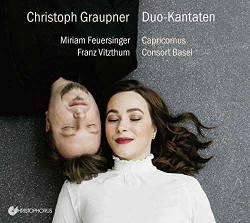 CD cover with man and woman lying on grey surface, white text and logo.