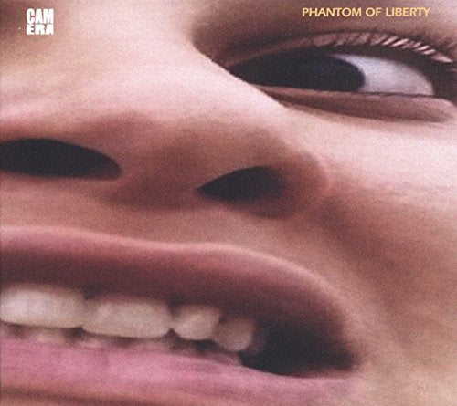 A close-up of a person's face with an open mouth and visible teeth.