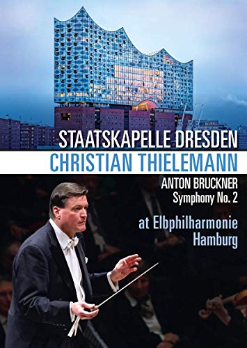 A conductor leads an orchestra, with a modern building above and text overlay.