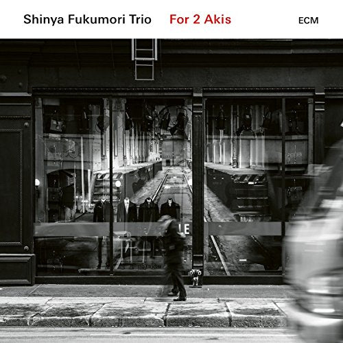 "Black and white CD cover with city street scene and blurred pedestrian."
