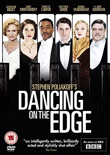 "DVD cover featuring six actors in formal attire standing behind a black fence."