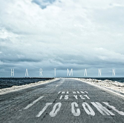 Album cover with a road leading to the sea and text "Hartmann, The best is yet to come".