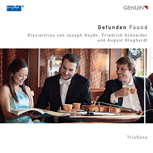 "CD cover featuring three musicians in formal attire smiling and reading sheet music together."