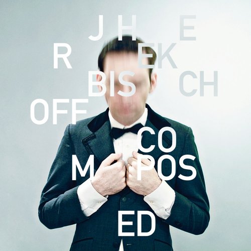 Man in tuxedo with hands on shirt, text overlay with album title and artist name.