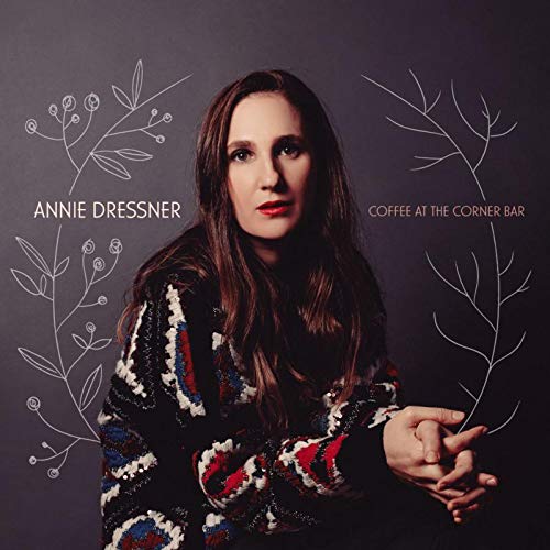 "CD cover featuring a woman with long brown hair and patterned sweater, surrounded by floral designs."
