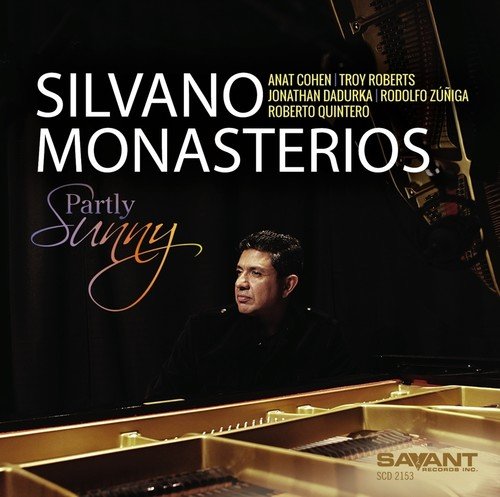 "Album cover with a man seated at a grand piano, dark background, white and gold text."