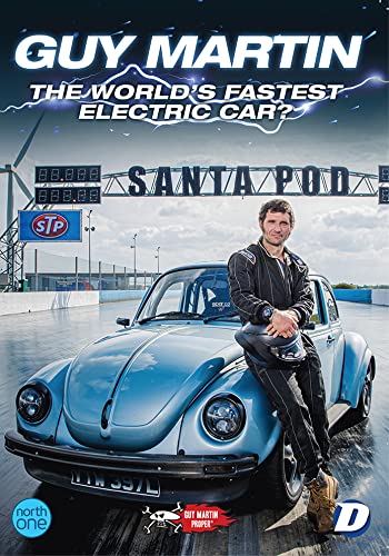 Guy Martin with a blue Volkswagen Beetle, racing track background.