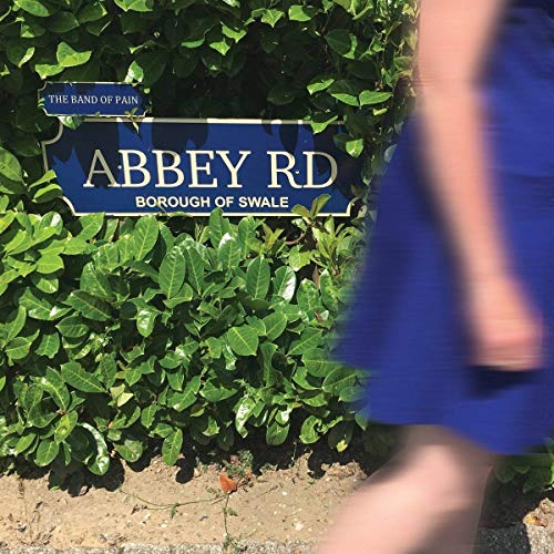 Blue "Abbey Rd" sign with green foliage and a partial figure.