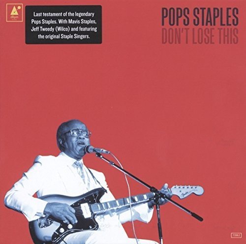 "Pops Staples in white, playing guitar and singing into a microphone, on a red album cover."