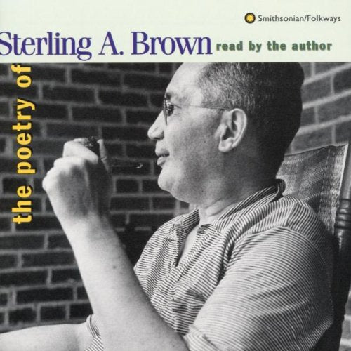 "Sterling A. Brown reads poetry, seated, smoking a pipe, against a brick wall."
