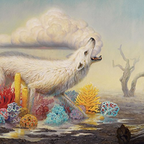 The image depicts a white wolf surrounded by colorful coral in shallow water.