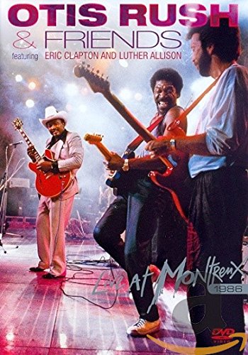 "Otis Rush and friends on stage with guitars, performing at a concert venue."