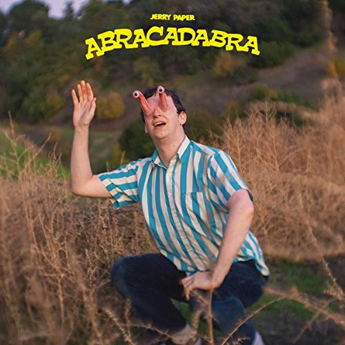 "Man crouching in dry grass, wearing novelty nose glasses, with 'Jerry Paper Abracadabra' text."