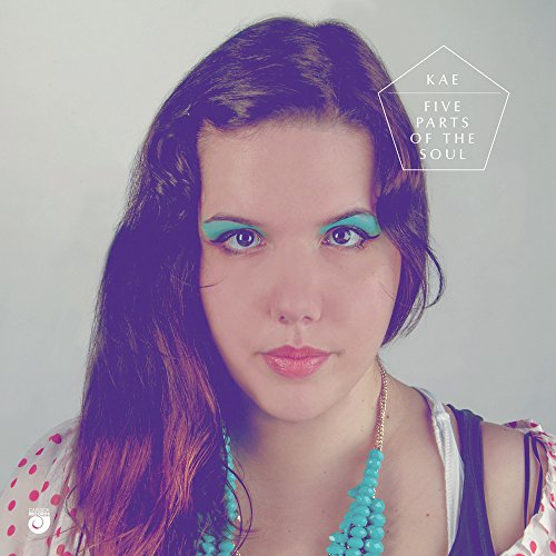 The image shows a woman with blue eye shadow and a blue necklace.
