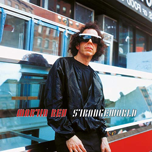 Album cover featuring a man in black clothing and sunglasses standing in front of a bus.