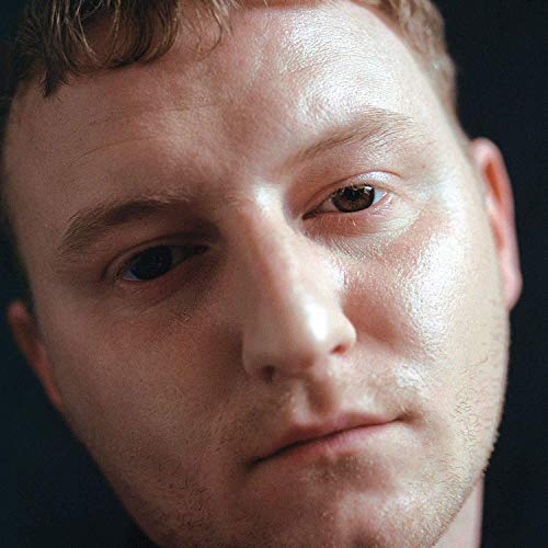 Close-up portrait of a young man with brown hair and eyes.