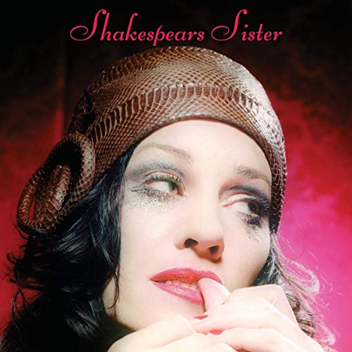 Close-up of a woman with dramatic makeup wearing a snakeskin cap.
