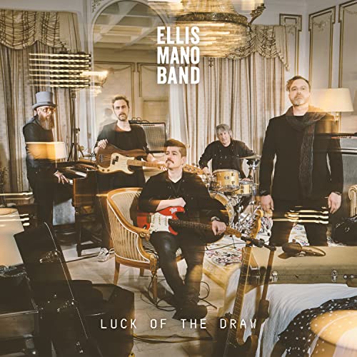 Four musicians with instruments pose in a vintage-style room.