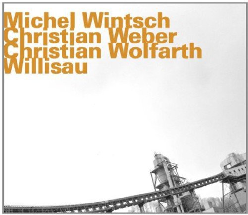 Album cover with orange text and industrial black-and-white image of a factory.