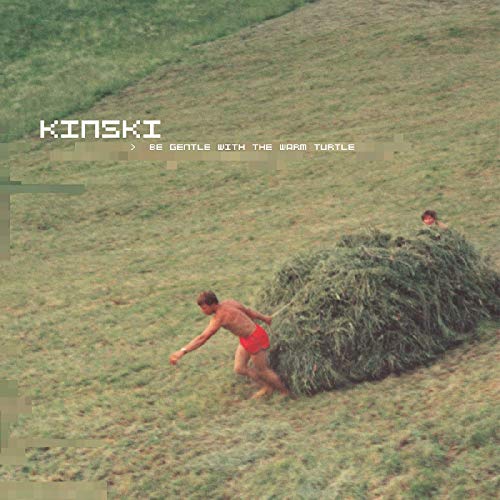 Album cover: man pulling hay bale on a grassy hill.