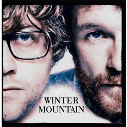 The alt text for the image is: "Album cover featuring close-up faces of two men with 'Winter Mountain' text."