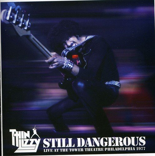 "Album cover featuring a man playing guitar on stage, logo, and title."