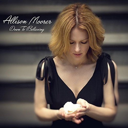 "Album cover featuring a woman in black holding seashells, with artist name and title."