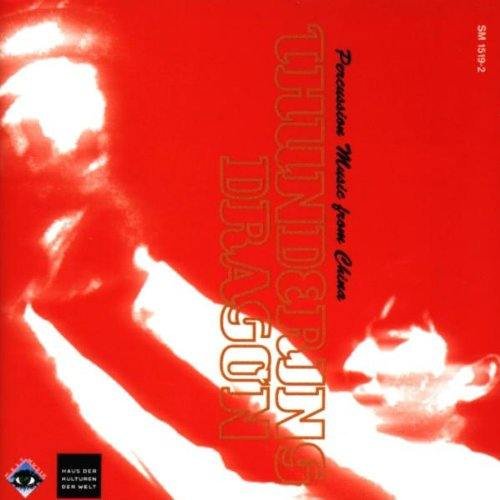 Red album cover with a blurred image of a man playing a drum.