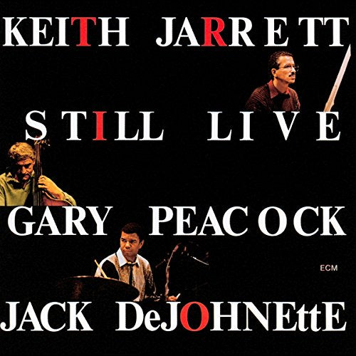 "CD cover with black background, three musicians, and white and red text."
