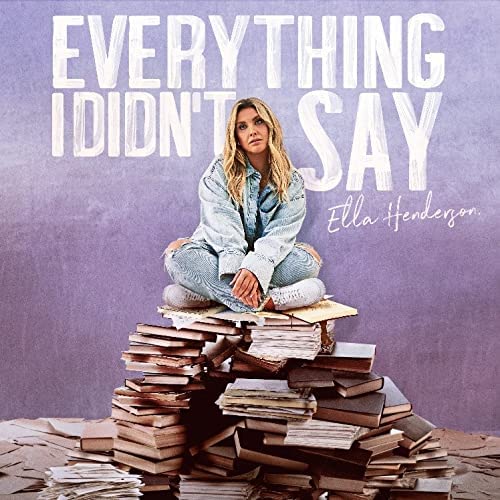 Album cover: blonde woman sitting on a stack of books against a purple background.