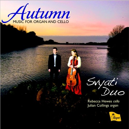 A man and woman stand by a river at sunset, with musical instrument.