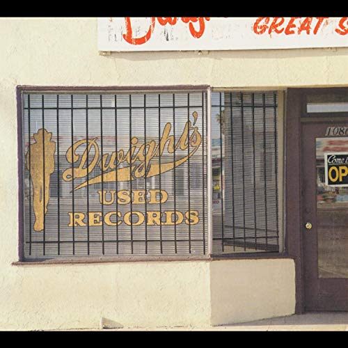 Dwight's Used Records storefront with barred window and gold signage.